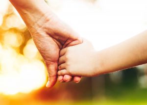 Adult holding hands with child