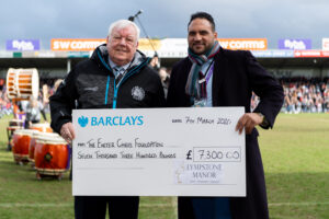 Exeter Chiefs CEO Tony Rowe OBE receives a cheque The Exeter Chiefs Foundation from Michael Caines